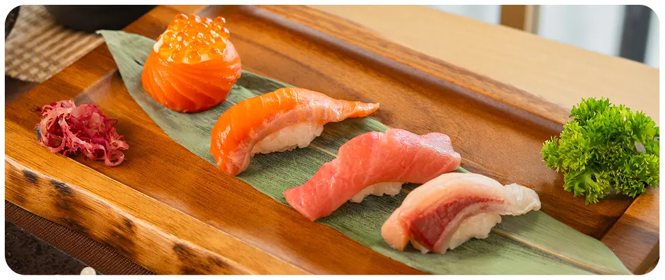 Salmon, tuna and ikura nigiri on a wooden board