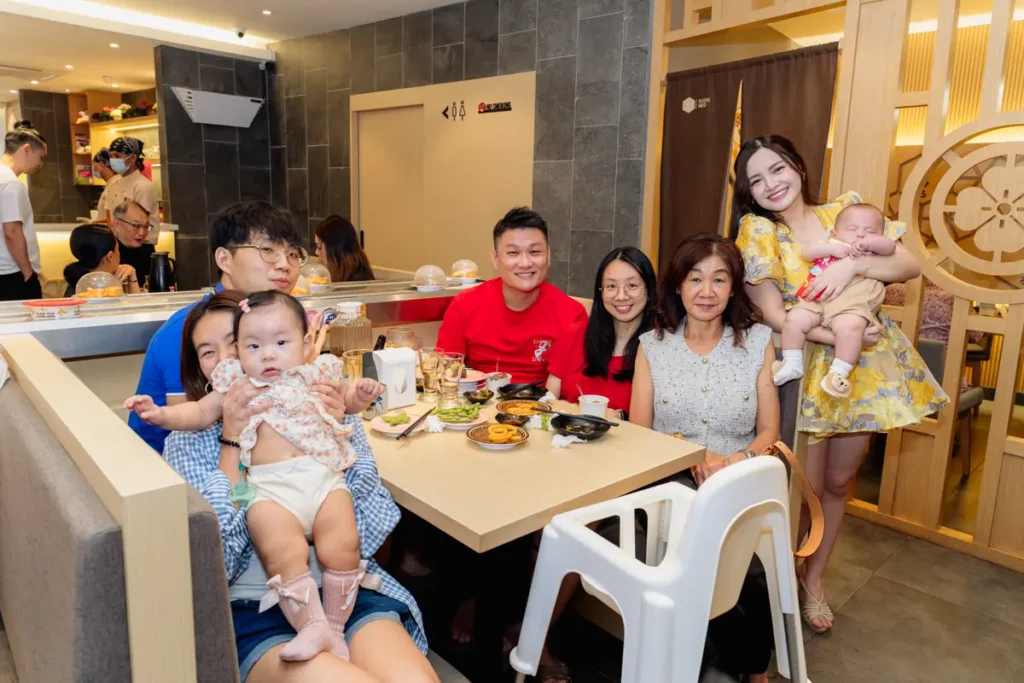 The family and friends sharing a meal at a Sushi Hiro booth